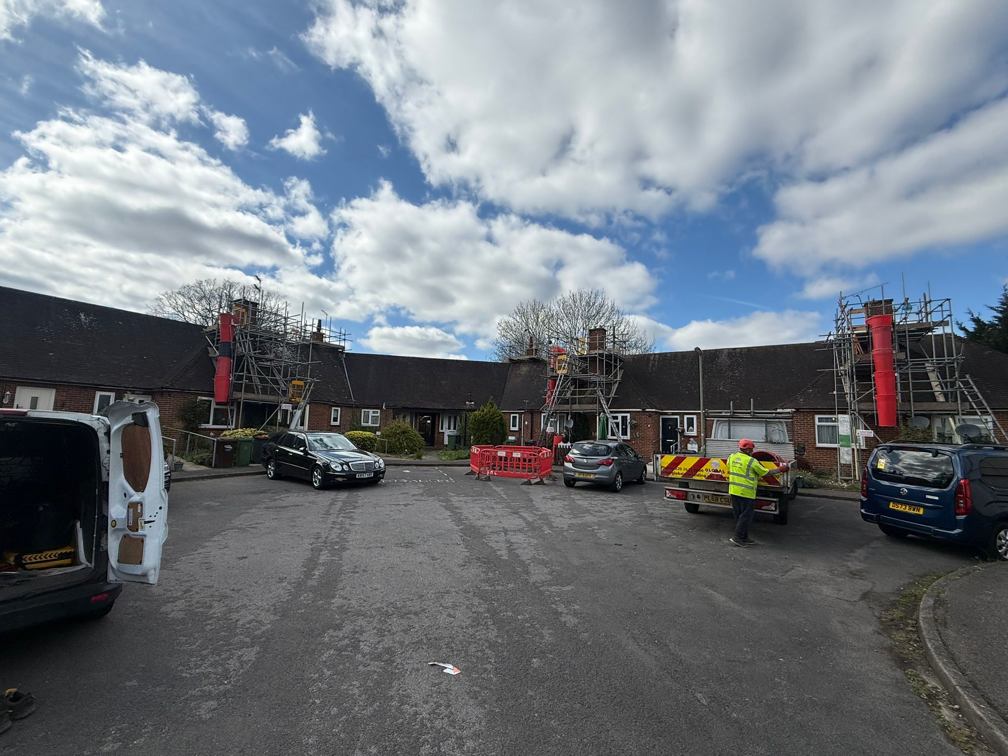 Scaffolding providing access to chimney stacks above pitched roofs